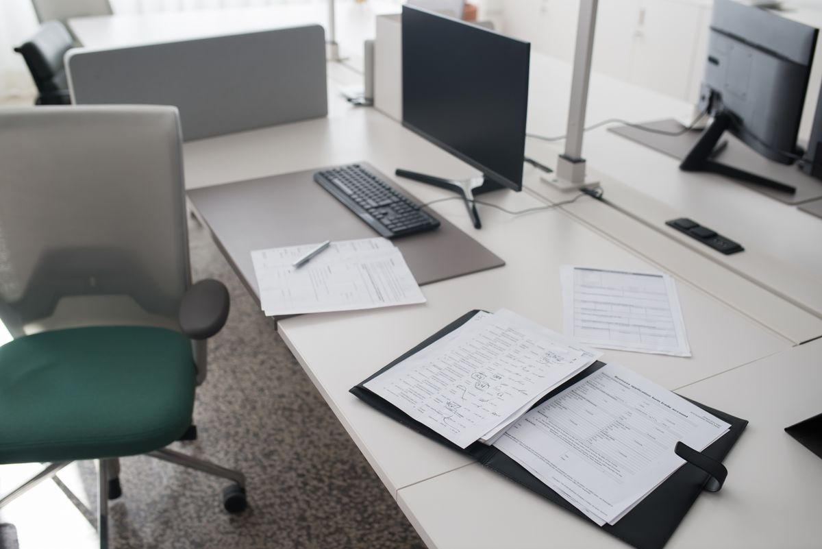 Compliance consultant reviewing audit documentation and standards in an office