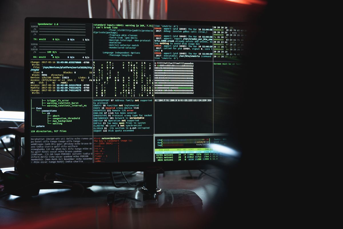 Cybersecurity analyst running a penetration test against a network on multiple monitors